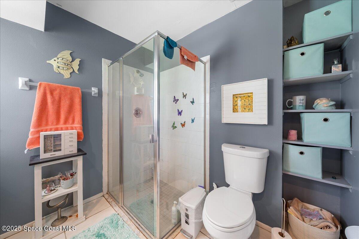 859 Riviera Drive Northeast Palm Bay, FL 32905 - Photo 17 of 26 a white toilet sitting next to a bathroom sink and a shower