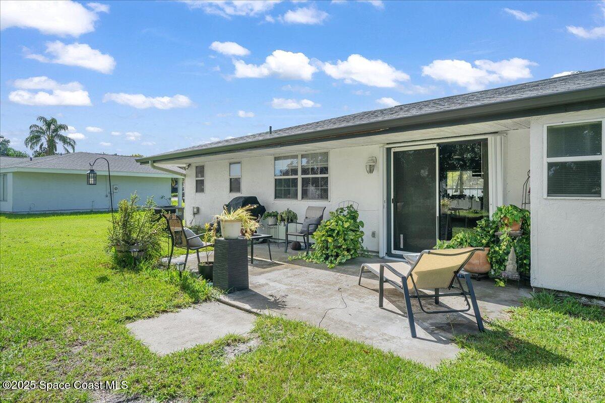 859 Riviera Drive Northeast Palm Bay, FL 32905 - Photo 23 of 26 a view of a house with backyard sitting area and garden