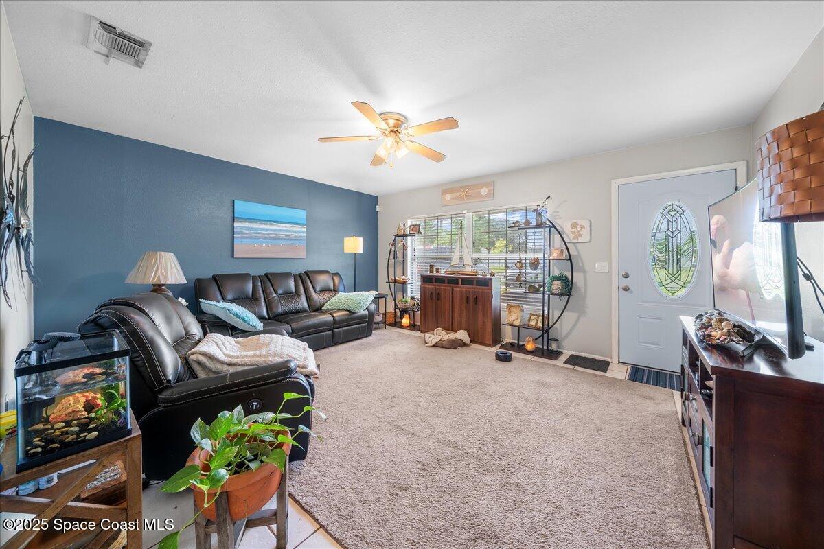 859 Riviera Drive Northeast Palm Bay, FL 32905 - Photo 8 of 26 a living room with furniture and a flat screen tv