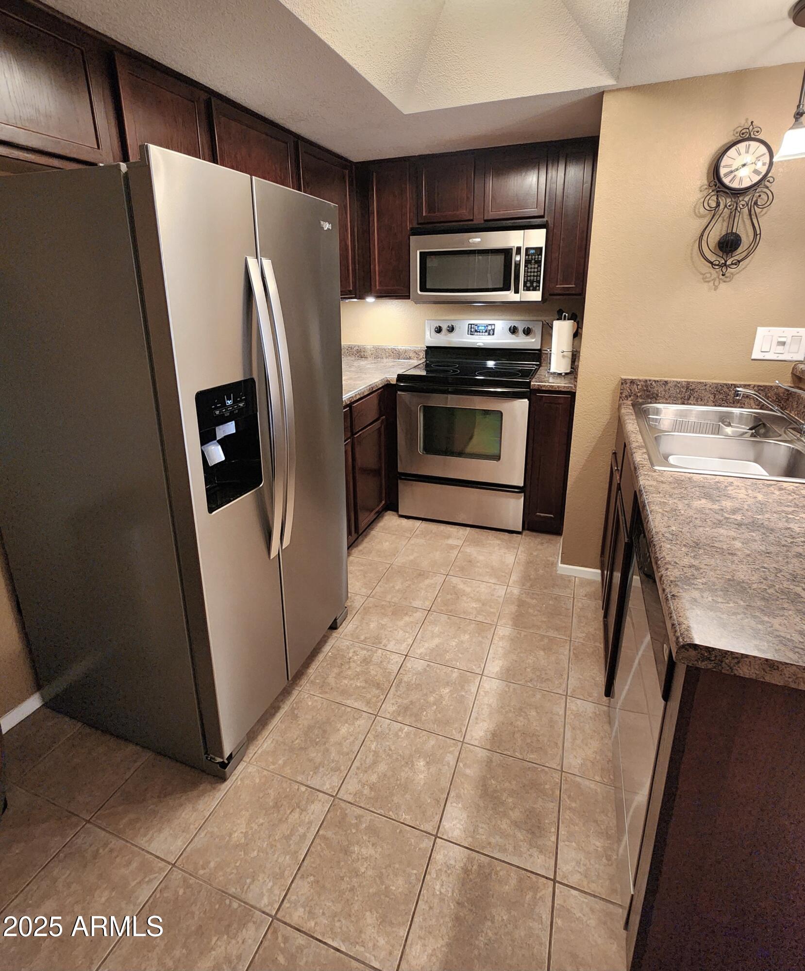 1720 East Thunderbird Road, Unit 2059 Phoenix, AZ 85022 - Photo 5 of 24 a kitchen with stainless steel appliances granite countertop a refrigerator a stove and a sink