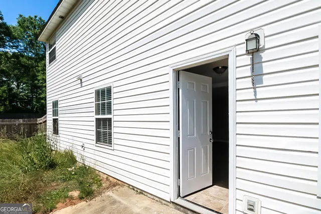 a view of a house with a door and a tree
