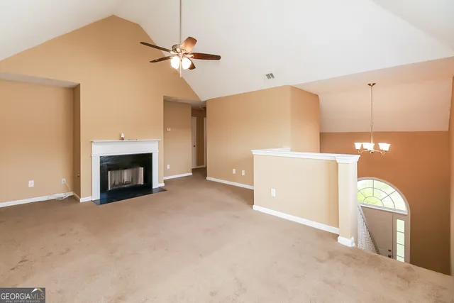 a view of a livingroom with a ceiling fan and a fireplace