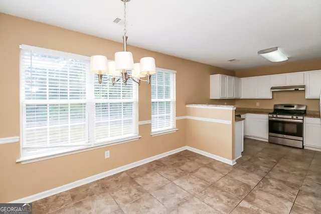 a kitchen with granite countertop a stove a sink and a refrigerator