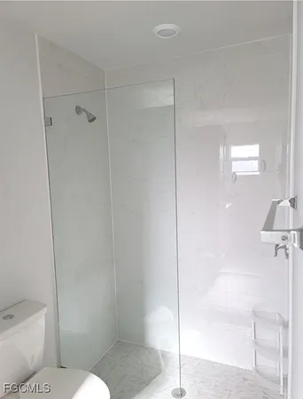 a bathroom with a toilet and a shower