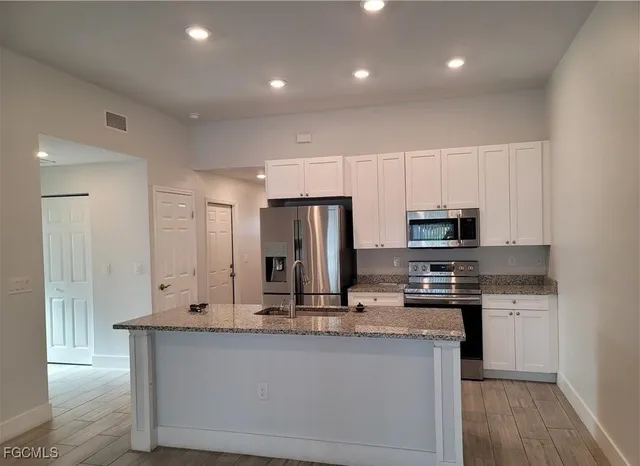 a kitchen with stainless steel appliances a sink stove and refrigerator