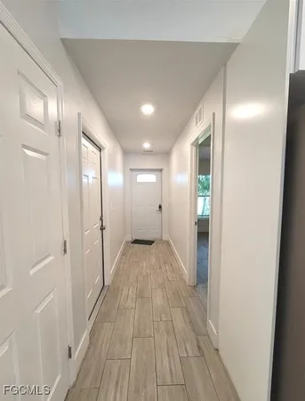 an empty room with wooden floor and window
