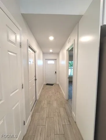 an empty room with wooden floor and window