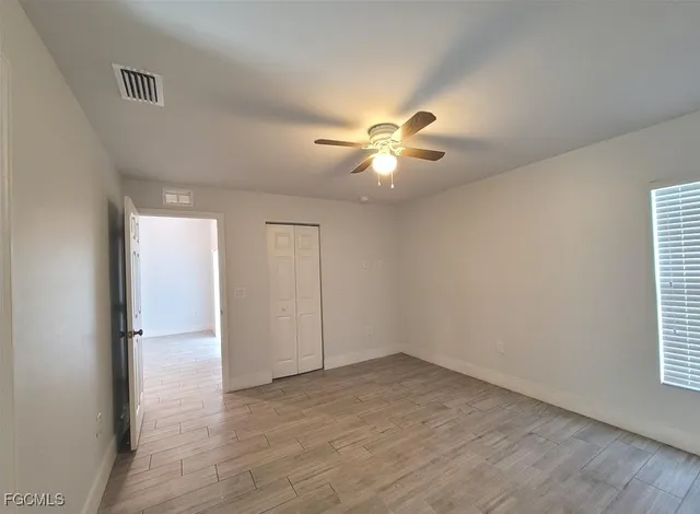 a view of an empty room with a chandelier fan