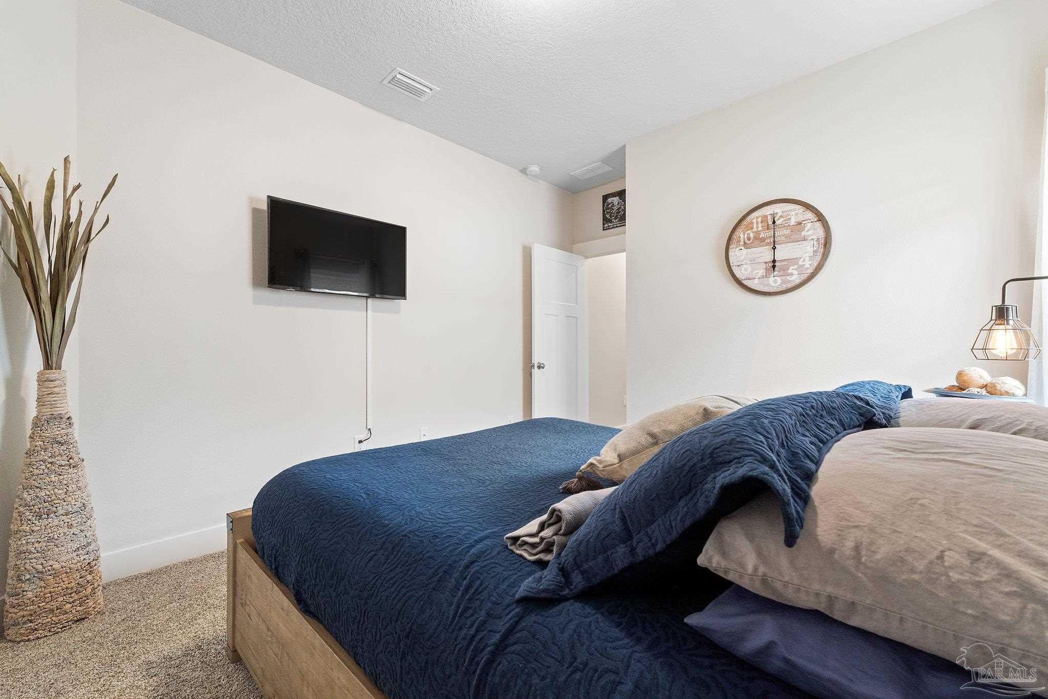 4483 Jude Way Pace, FL 32571 - Photo 18 of 30 a bedroom with a bed and a flat screen tv