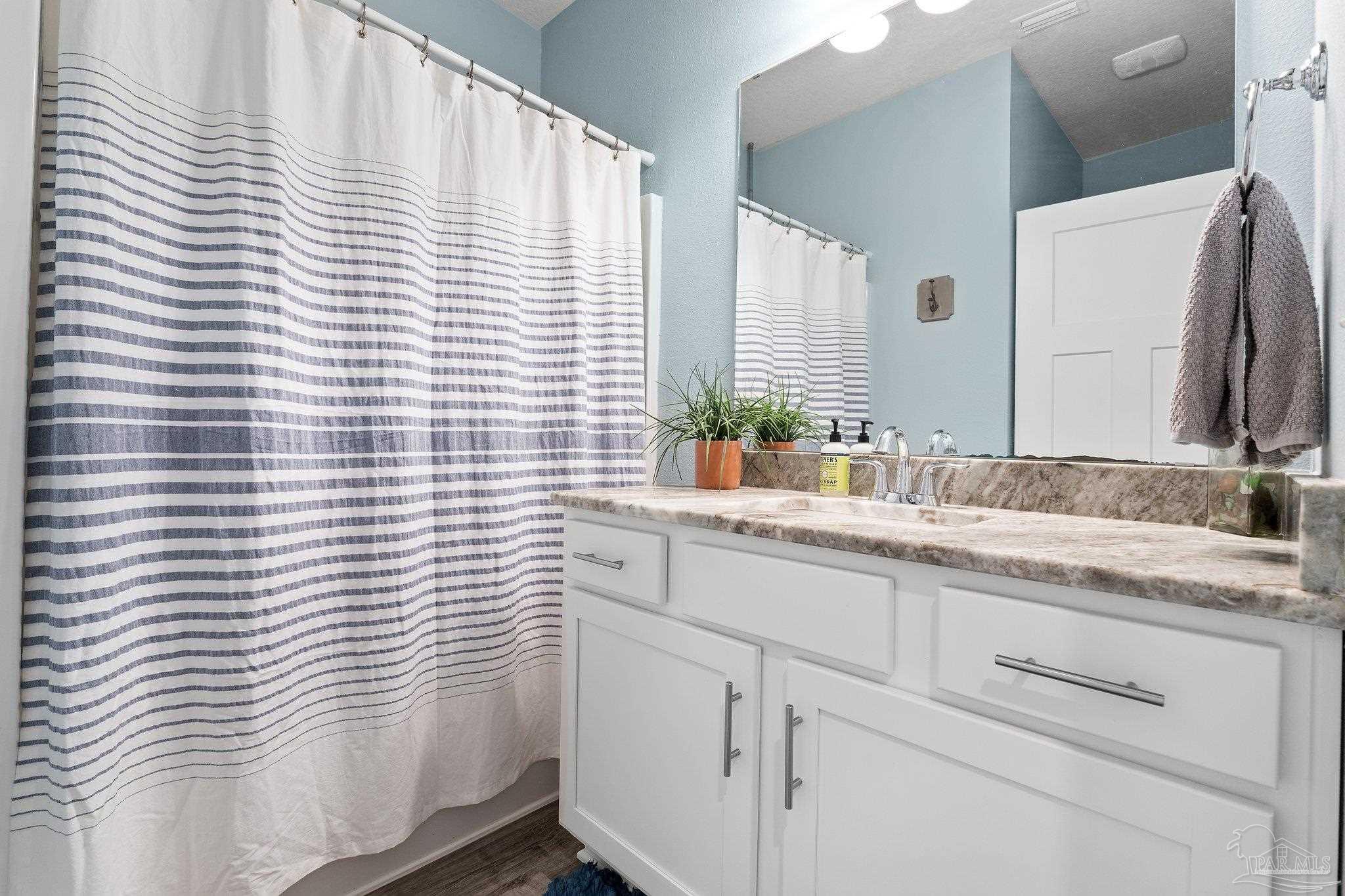 4483 Jude Way Pace, FL 32571 - Photo 21 of 30 a bathroom with a granite countertop sink and a window
