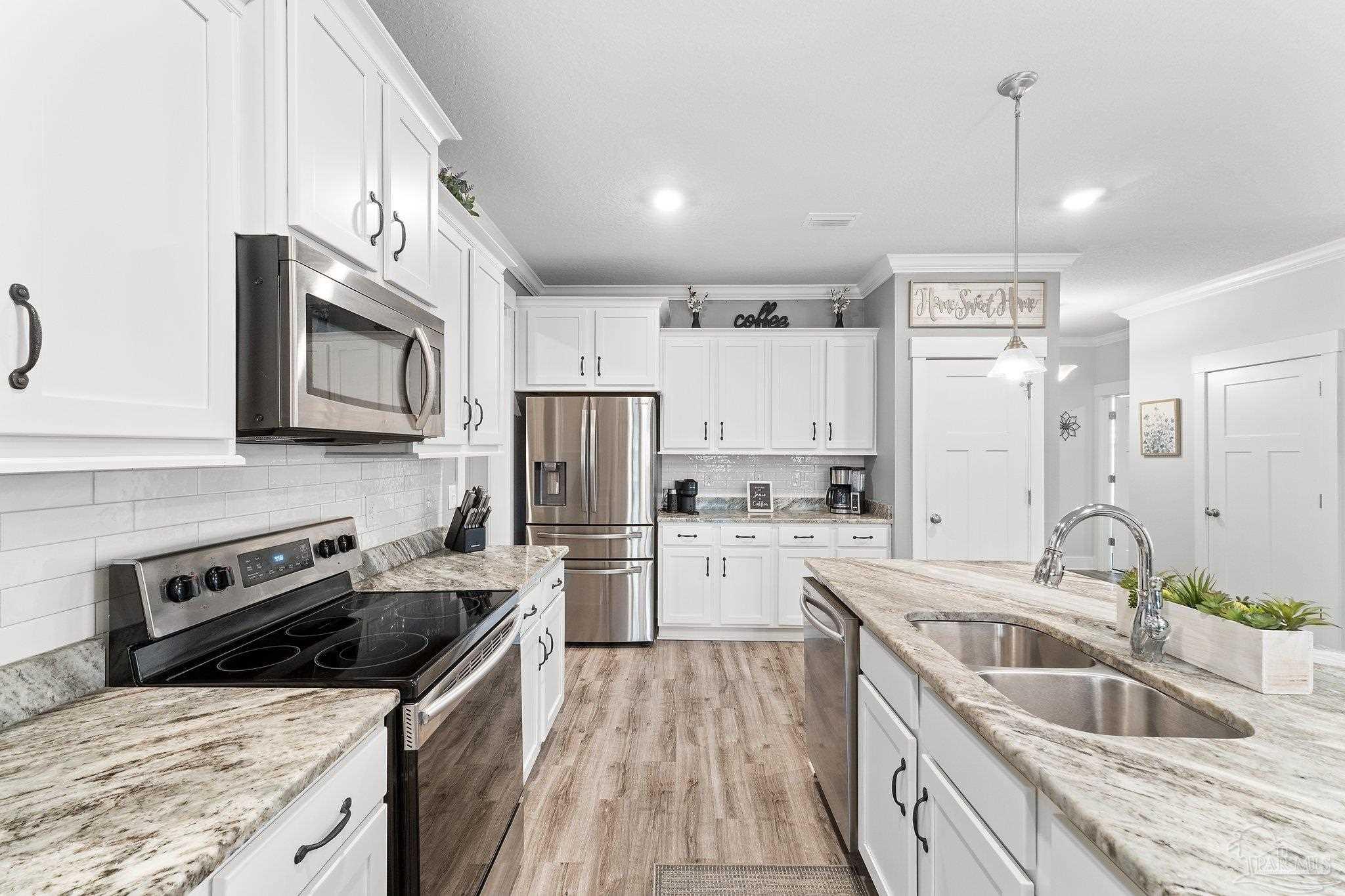 4483 Jude Way Pace, FL 32571 - Photo 30 of 30 a kitchen with a sink stove and refrigerator