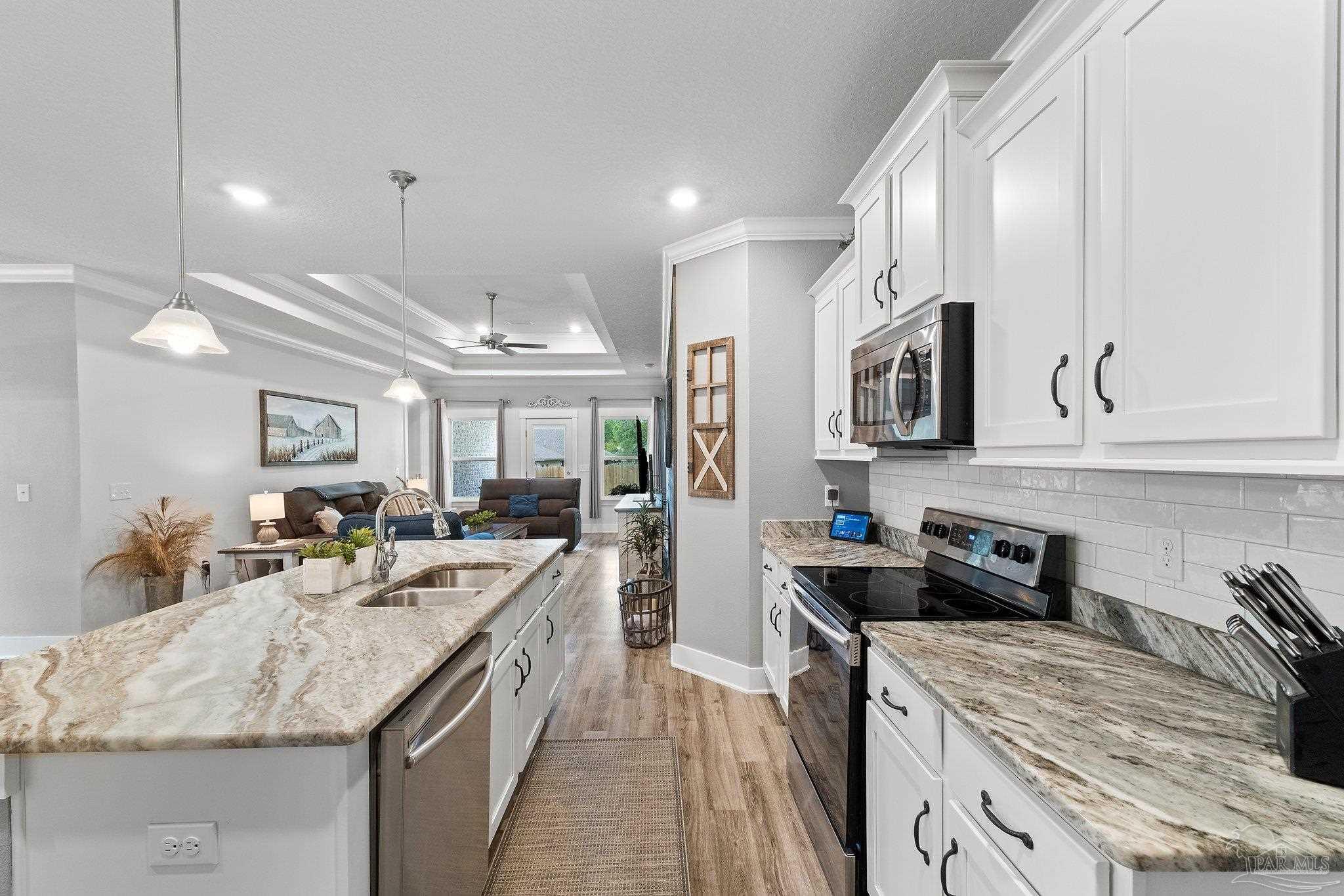 4483 Jude Way Pace, FL 32571 - Photo 5 of 30 a kitchen with stainless steel appliances granite countertop sink stove and refrigerator