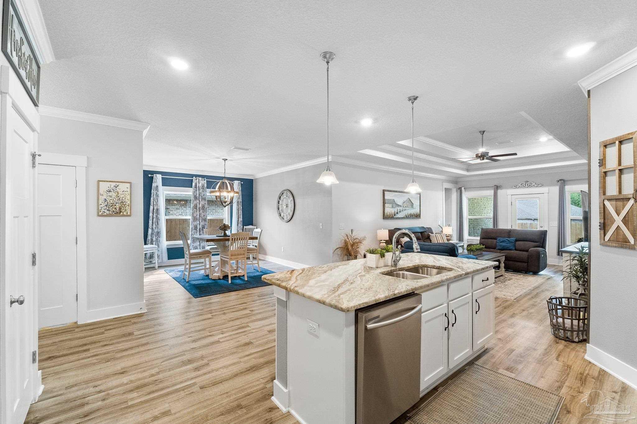 4483 Jude Way Pace, FL 32571 - Photo 7 of 30 a kitchen with a stove a counter space a sink and living room view