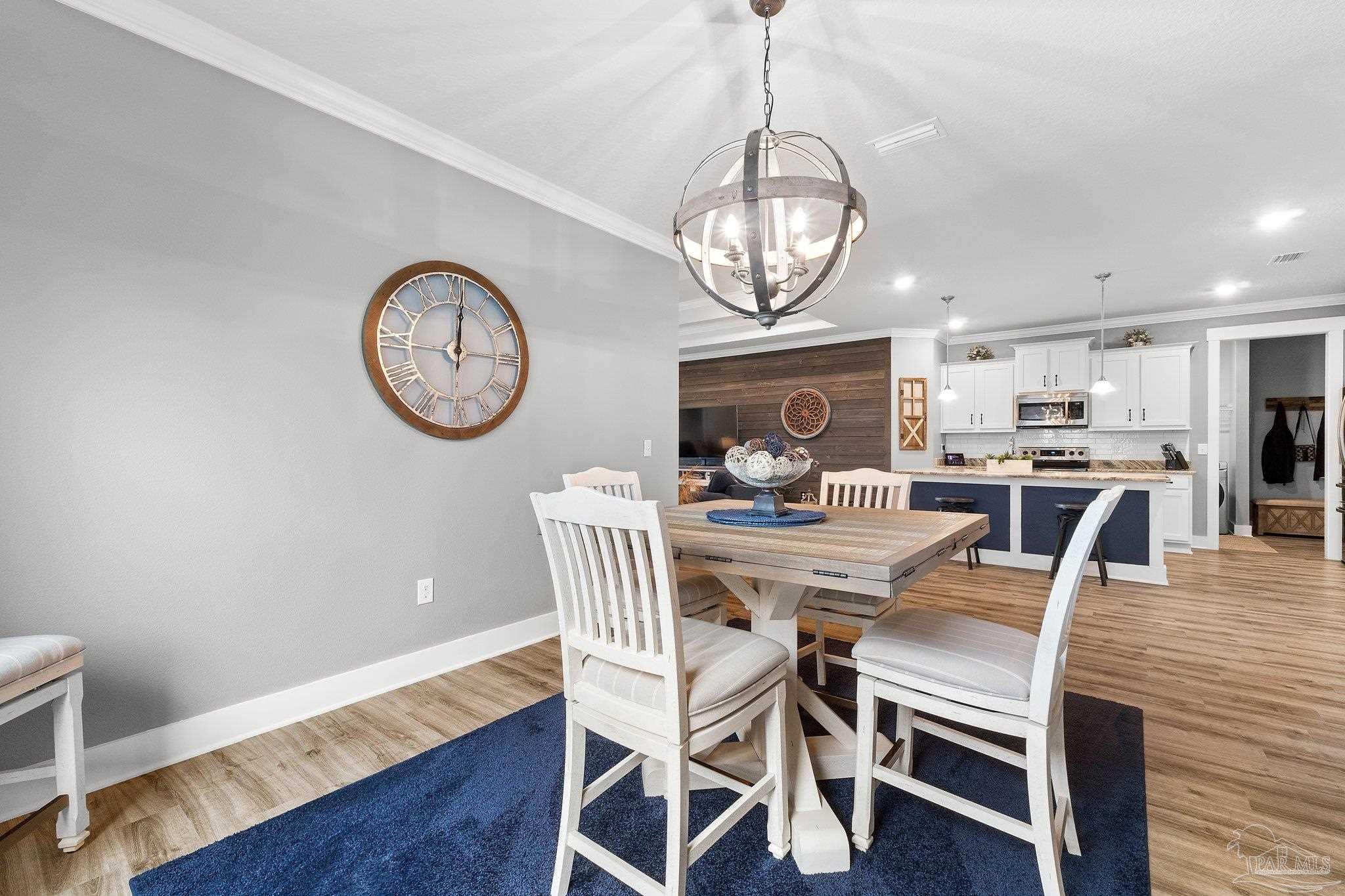 4483 Jude Way Pace, FL 32571 - Photo 9 of 30 a view of a dining room with furniture a chandelier and wooden floor