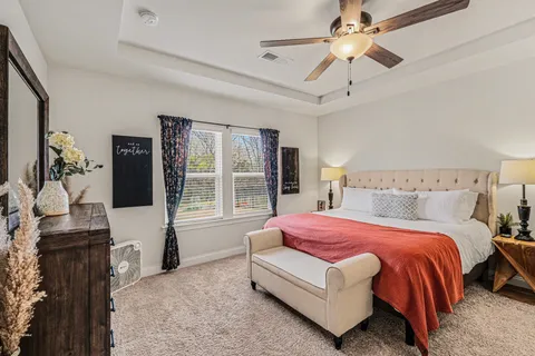 a bedroom with a bed mirror and window