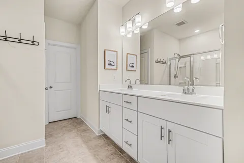 a bathroom with double sink and a mirror