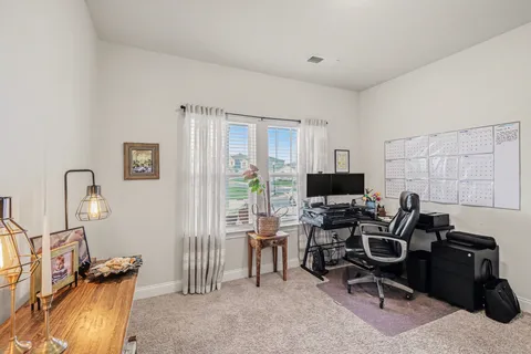 a view of a workspace with furniture and a window