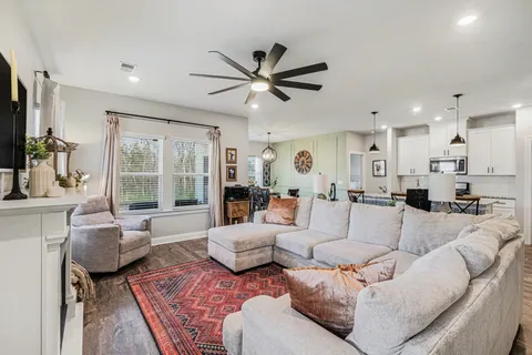 a living room with furniture kitchen view and a large window
