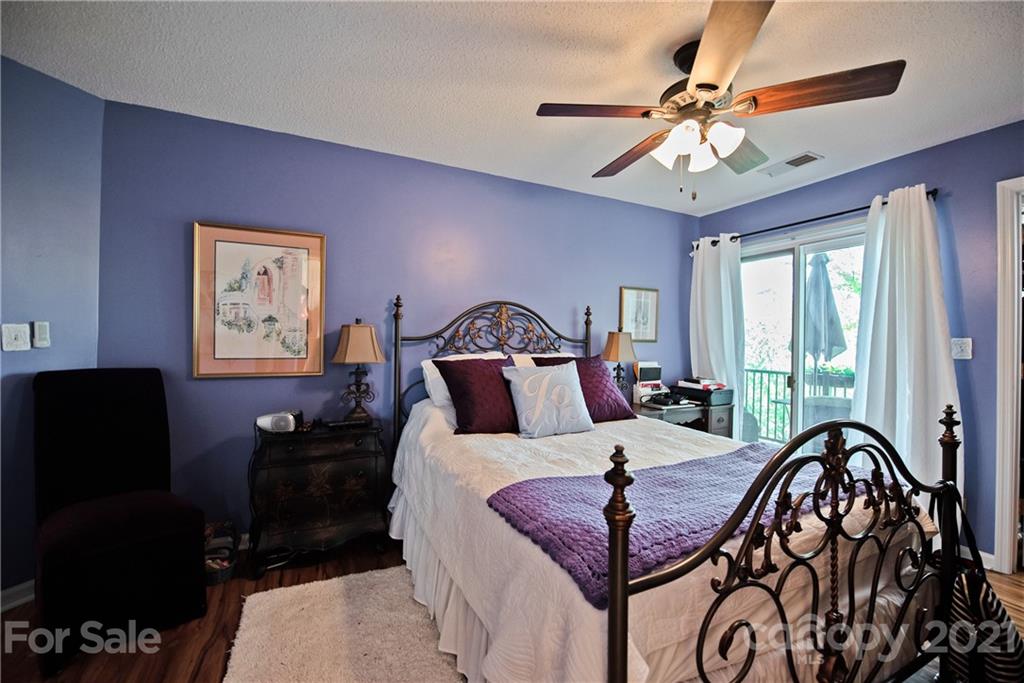 18809 Nautical Drive, Unit 302 Cornelius, NC 28031 - Photo 13 of 22 a bedroom with a bed a chandelier and a dresser