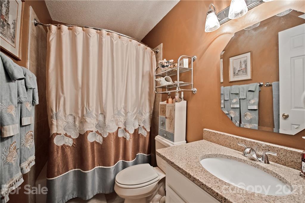 18809 Nautical Drive, Unit 302 Cornelius, NC 28031 - Photo 17 of 22 a bathroom with a granite countertop bathtub sink vanity mirror and toilet