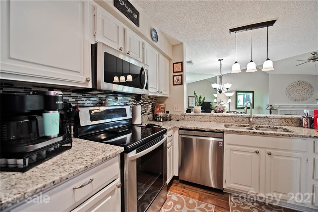 18809 Nautical Drive, Unit 302 Cornelius, NC 28031 - Photo 7 of 22 a kitchen with stainless steel appliances granite countertop a stove microwave and sink