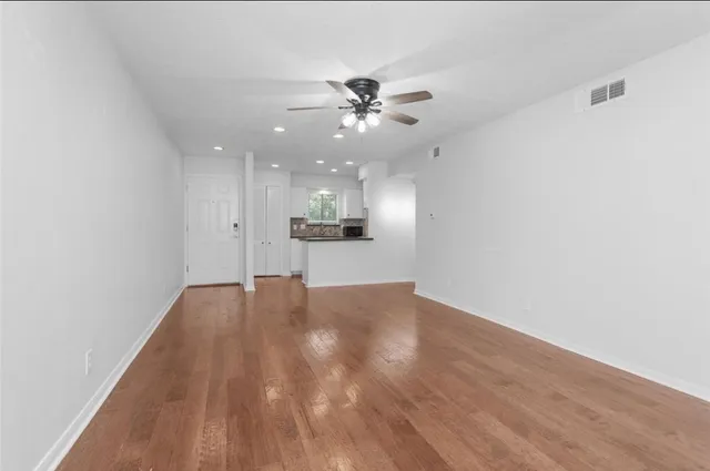 a view of an empty room and kitchen view