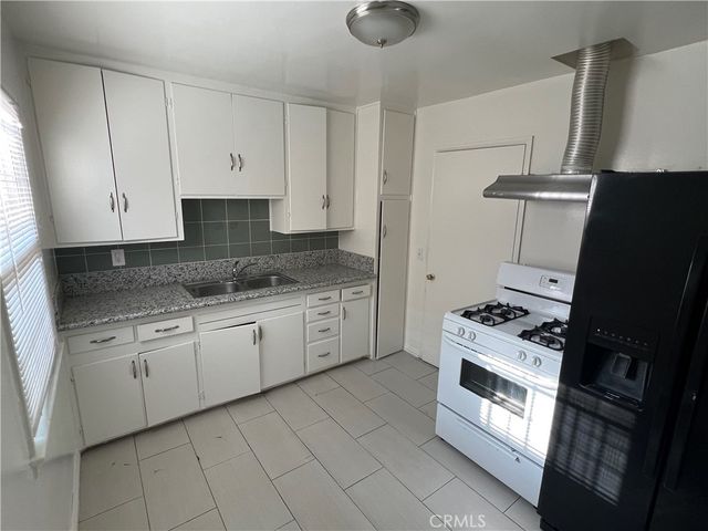 a kitchen with granite countertop cabinets stainless steel appliances and a sink