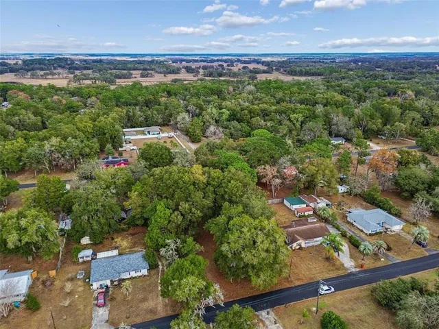 an aerial view of a house with a yard and lake view
