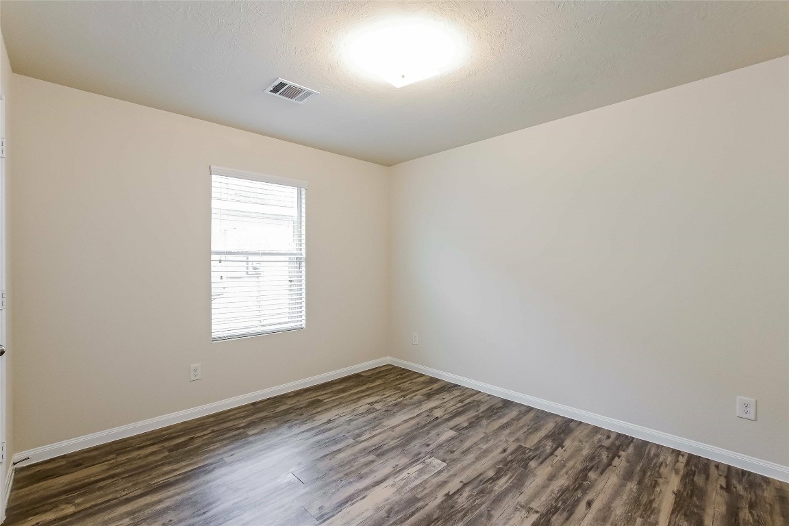 5506 Paiges Way Katy, TX 77449 - Photo 12 of 17 an empty room with wooden floor and windows