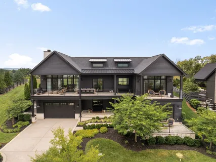 a front view of a house with a garden and swimming pool