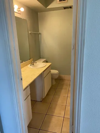 a bathroom with a granite countertop sink a toilet and a mirror