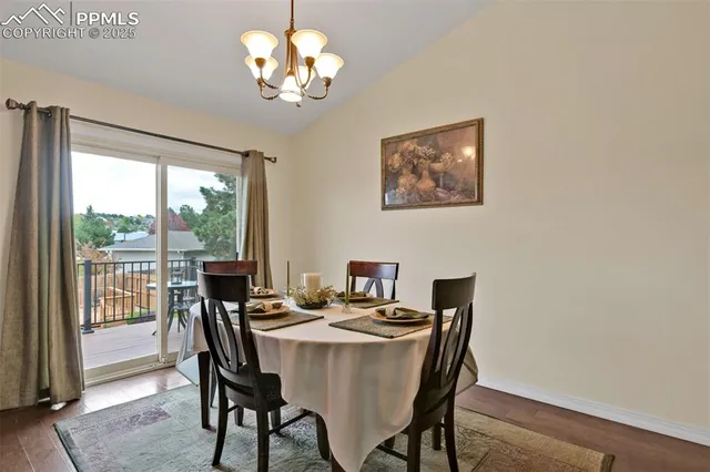 a view of a dining room with furniture a chandelier and wooden floor