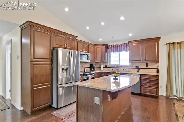 a kitchen with a refrigerator sink and cabinets