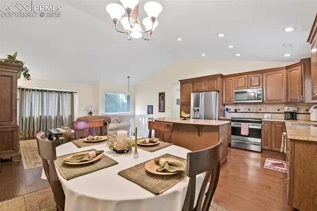 a living room with stainless steel appliances kitchen island granite countertop furniture and a dining table