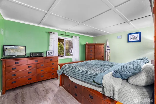 a bedroom with a large bed and a flat tv screen