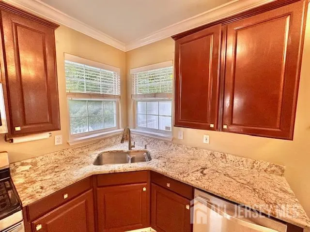 a kitchen with granite countertop wooden cabinets a sink and a window