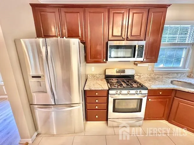 a kitchen with stainless steel appliances granite countertop a refrigerator and a stove