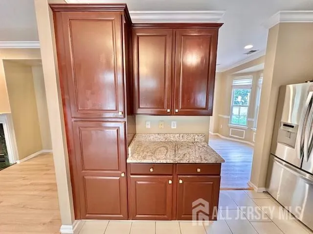 a kitchen with a refrigerator and wooden floor