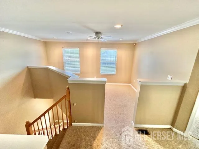 a view of an empty room with window and chandelier fan