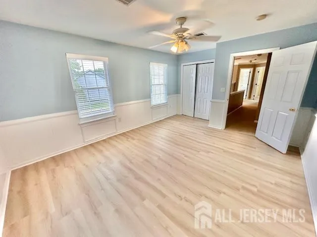 a view of a room with wooden floor and ceiling fan