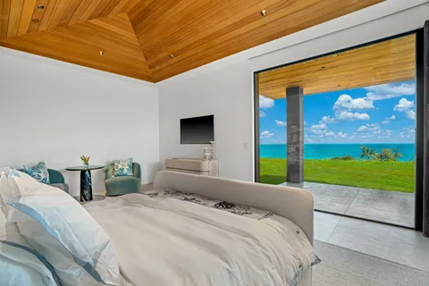 a bedroom with a bed and large windows