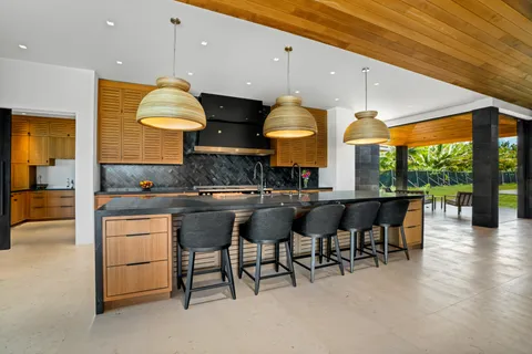 a kitchen with stainless steel appliances granite countertop a sink a stove and a wooden floors