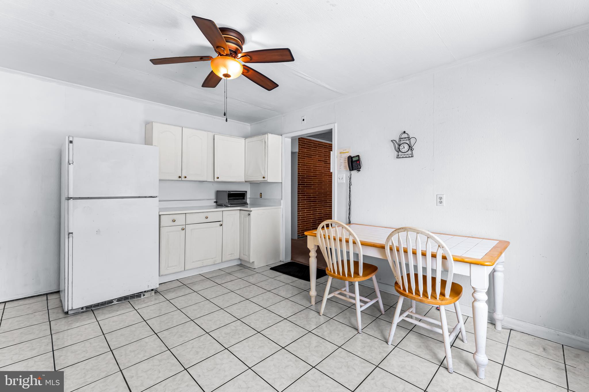 1112 Owens Road Oxon Hill, MD 20745 - Photo 14 of 30 a kitchen with a cabinets a refrigerator and a table