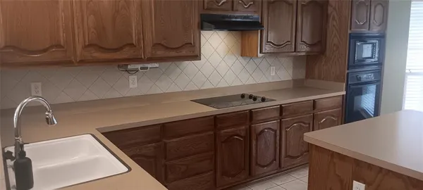 a kitchen with stainless steel appliances a sink dishwasher stove and cabinets