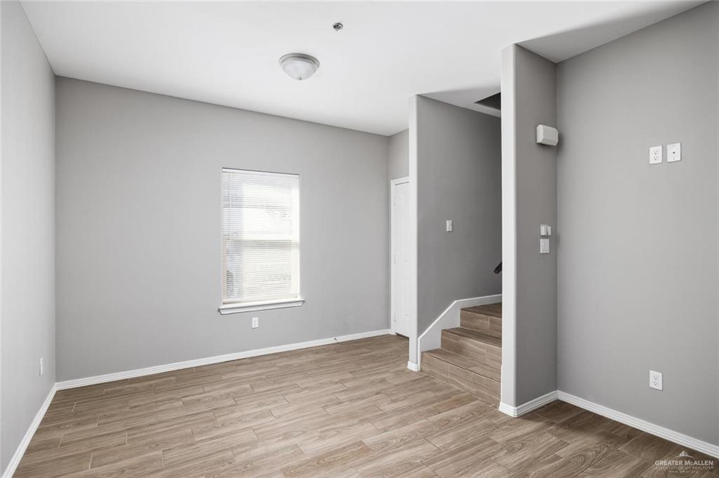 1400 Humming Bird Court, Unit 5 Pharr, TX 78577 - Photo 5 of 8 a view of an empty room with wooden floor and a window