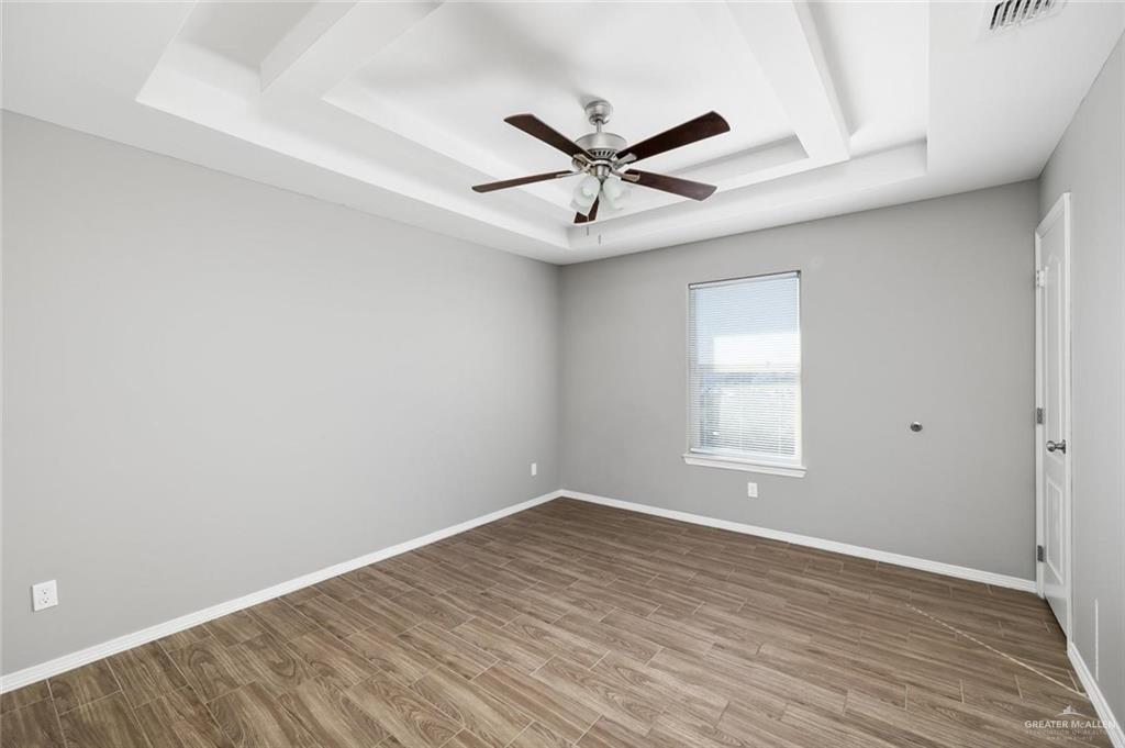 1400 Humming Bird Court, Unit 5 Pharr, TX 78577 - Photo 6 of 8 an empty room with wooden floor fan and windows