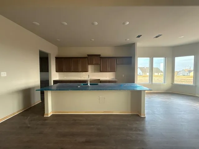 a view of kitchen with wooden floor and electronic appliances