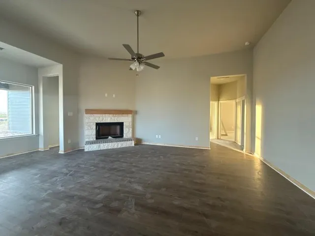 a view of an empty room with a fireplace and a window