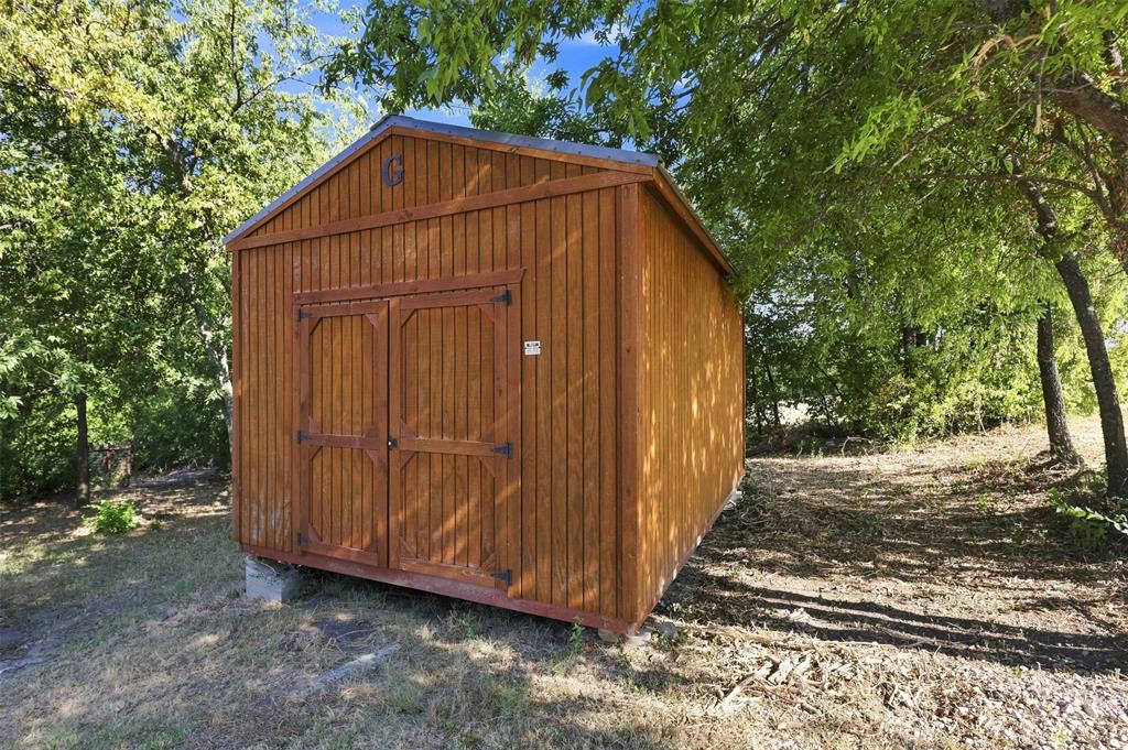 5519 Upper Denton Road Weatherford, TX 76085 - Photo 34 of 38 Wood-sided utility shed with double doors and an angled roofline