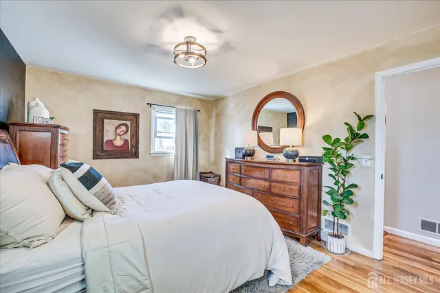 a bedroom with a bed and a dresser with mirror